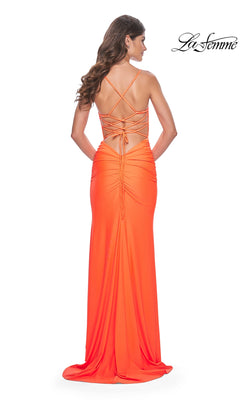 A woman wears the La Femme Open-Back Bright Long Prom Dress 32321, featuring a fitted silhouette, ruched details, and crisscross strappy open back—perfect for making a statement. "La Femme" logo appears in the top right corner.