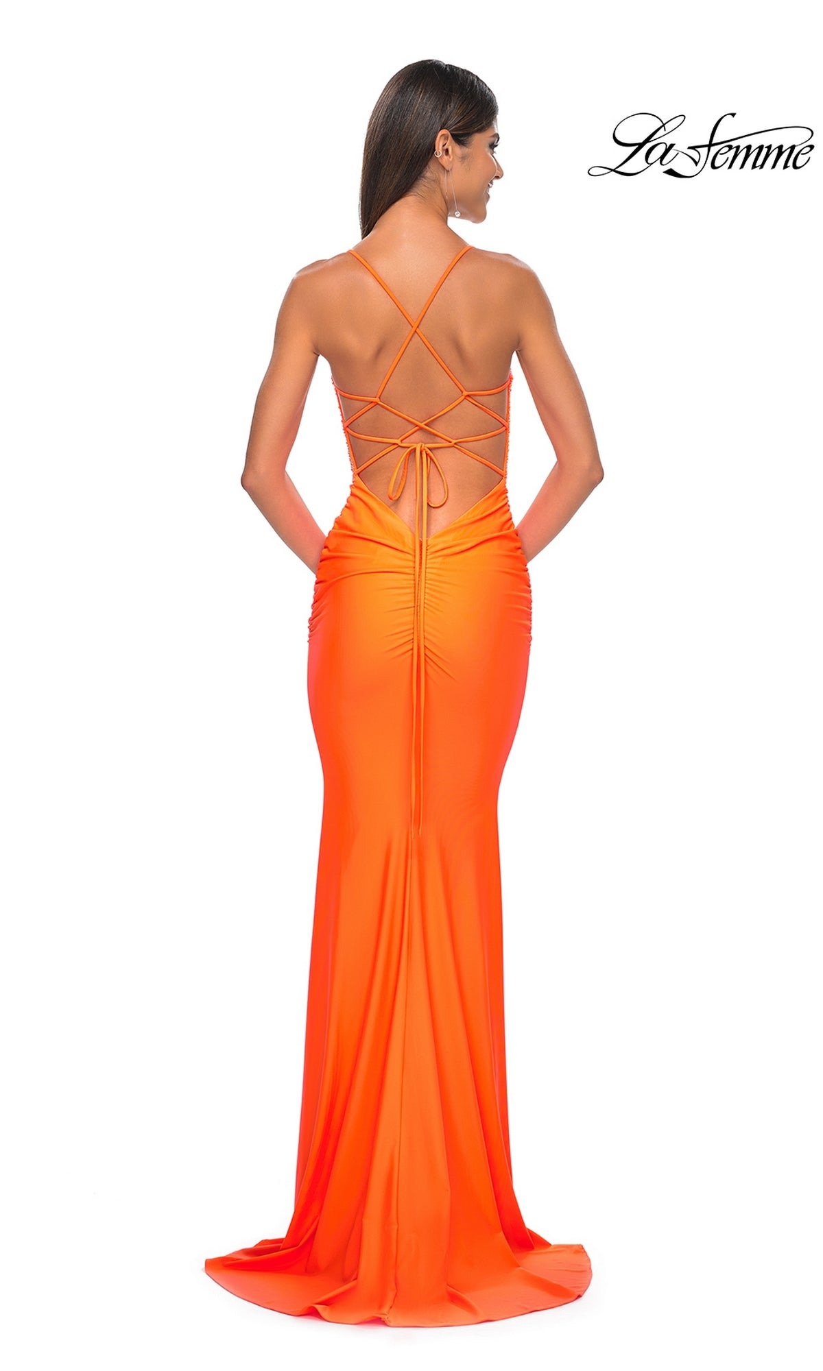 A woman seen from behind wearing the La Femme Backless Bright Long Prom Dress 32325 in orange, featuring a floor-length skirt, ruched back, and crisscrossed open back straps.