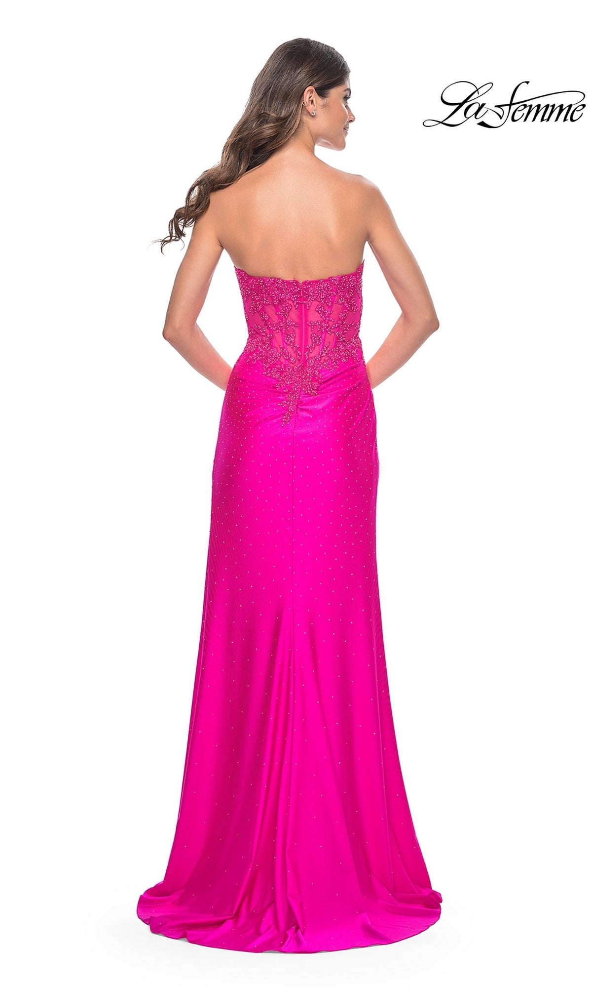 Model showcases the La Femme Strapless Hot Pink Long Prom Dress 32329, featuring beaded detailing and a lace-up back, viewed from behind.