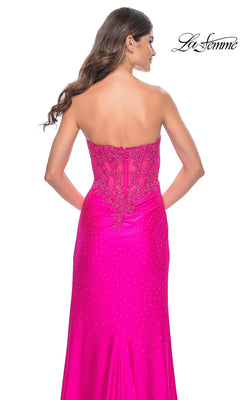 A woman with long brown hair is shown from behind wearing the La Femme Strapless Hot Pink Long Prom Dress 32329, featuring lace and sequin details on the back. The La Femme logo appears in the top right corner.
