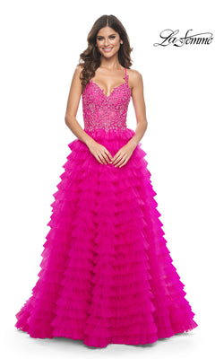 A woman smiles in the La Femme Hot Pink Long Ruffled Prom Dress 32334, featuring an embroidered-lace bodice and a ruffled a-line skirt. The La Femme logo is displayed in the top right corner.