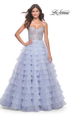 A woman smiles against a white background, wearing the La Femme Long Tiered A-Line Prom Dress 32335 with a sleeveless silver beaded sweetheart corset and a layered lavender tulle skirt featuring a thigh-high side slit.