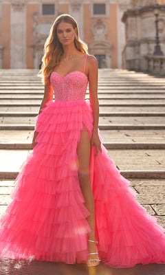 A woman stands on stone steps wearing the La Femme Long Tiered A-Line Prom Dress 32335 in bright pink, featuring a strapless design and thigh-high side slit, paired with gold high-heeled sandals.