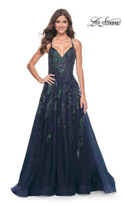 A woman stands smiling in the La Femme Long A-Line Sequin-Print Prom Dress 32346, a navy blue floor-length gown with green embellishments. The La Femme logo is shown in the top right corner.