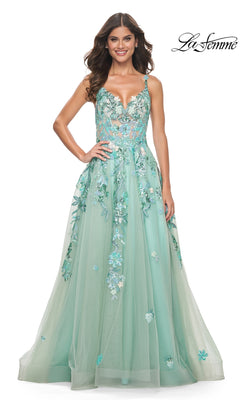A woman wearing the La Femme Sequin-Print Long Green Prom Dress 32347, a sleeveless formal gown with sequin details and a tulle skirt, stands smiling against a white background.