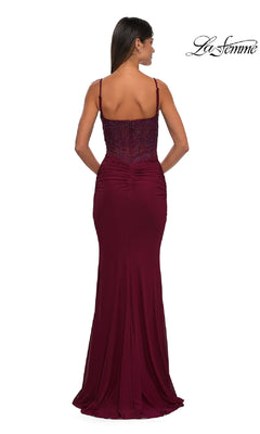 A woman is pictured from the back wearing the La Femme 32357, a sleeveless, floor-length burgundy prom dress with thin straps and a fitted ruched bodice. The La Femme logo is visible in the top right corner.