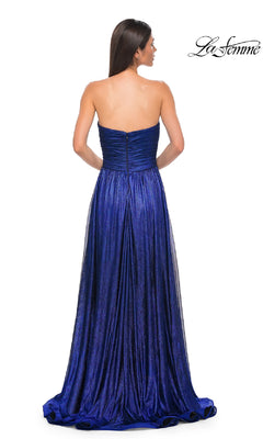 A woman models the Strapless Long Metallic Prom Dress (La Femme 32382), featuring a fitted bodice and pleated skirt in royal blue. Photographed from the back, with the La Femme logo in the top right corner.