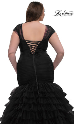 A woman is shown from behind wearing the La Femme 32389, a plus-size long mermaid prom dress with black cap sleeves, lace-up back detailing, and layered tulle ruffles at the bottom.