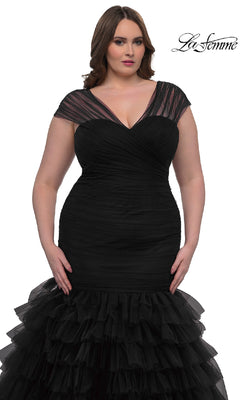 A woman models the Plus-Size Long Mermaid Prom Dress La Femme 32389, featuring fitted black cap sleeves, sheer details, and a ruffled skirt, standing against a white background with the La Femme logo in the top right corner.