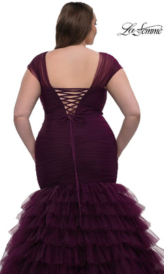 A woman is shown from behind wearing the La Femme 32389 plus-size long mermaid prom dress in deep purple, featuring a ruched silhouette, lace-up back, and tiered tulle skirt.