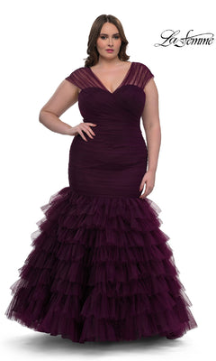 A woman models the La Femme 32389, a plus-size long mermaid prom dress in deep purple with sheer cap sleeves, a fitted ruched bodice, and a tiered tulle skirt. The La Femme logo appears in the top right corner.