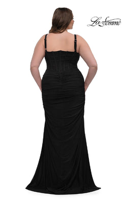 A woman models the Plus-Size Sexy Long Prom Dress: La Femme 32402, a fitted black gown with ruched details, wide shoulder straps, corset-style bodice, floor-length hemline, slight train, and elegant back view.