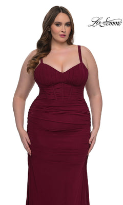 A woman wears the Plus-Size Sexy Long Prom Dress La Femme 32402, a fitted sleeveless burgundy gown with ruched detailing, wide straps, and a corset-style bodice. She stands against a plain white background with the "La Femme" logo in the top right corner.