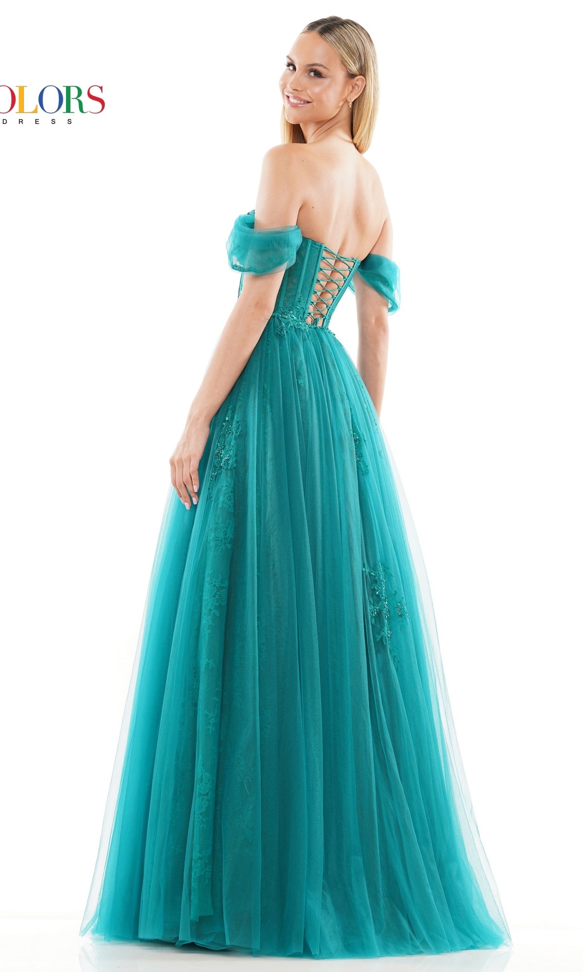 Woman wearing the Long Sweetheart Prom Ball Gown: Colors Dress 3240 in teal, featuring an off-the-shoulder neckline and lace-up back, stands smiling over her shoulder against a white background.