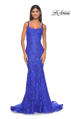 A woman models the fitted, floor-length Long Lace Mermaid Prom Dress: La Femme 32420 in royal blue, featuring wide shoulder straps and a subtle mermaid silhouette, against a plain white background.