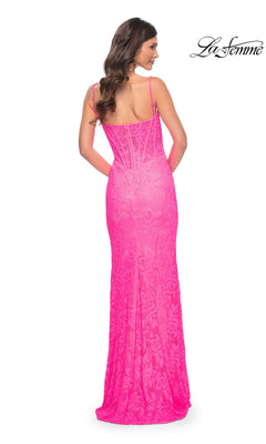 Woman in a fitted, floor-length neon pink lace prom dress with thin straps, shown from the back. This stunning gown is the Neon Pink Long Lace Prom Dress: La Femme 32423.