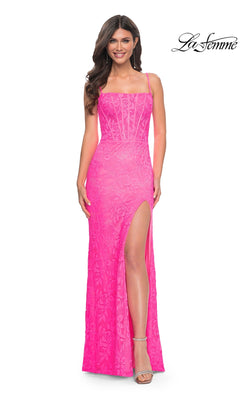 A woman smiles in the Neon Pink Long Lace Prom Dress: La Femme 32423, featuring spaghetti straps, lace details, and a high slit. "La Femme" logo appears in the corner.