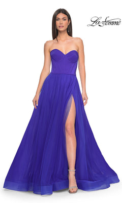A woman models the Strapless Long Tulle Prom Dress: La Femme 32424 in deep blue, featuring a sweetheart neckline, corset-style bodice, and thigh-high slit, set against a plain white background.