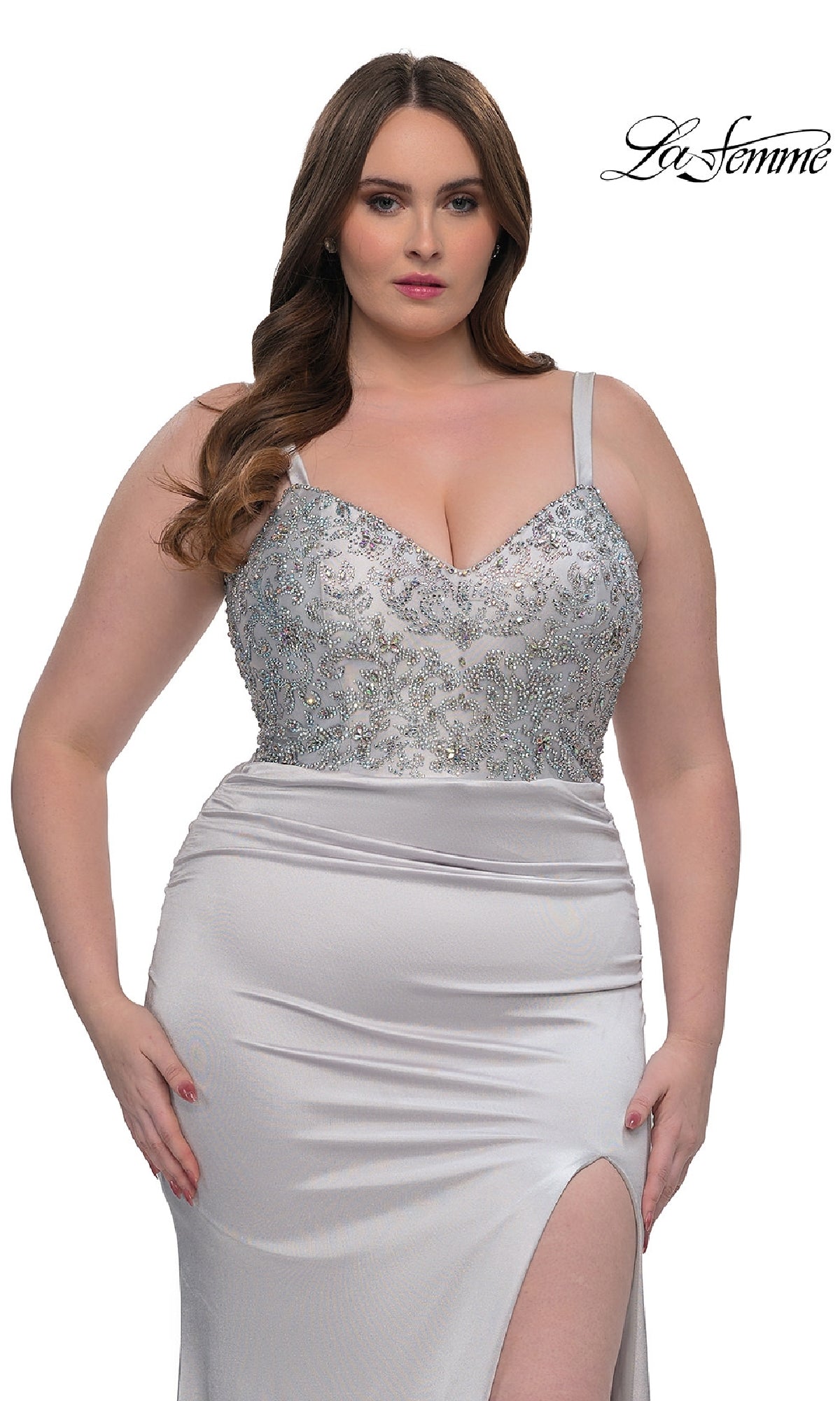 A woman wears the Plus-Size Long Satin Prom Dress, La Femme 32430, in silver with a rhinestone-beaded bodice, spaghetti straps, and a thigh-high slit. The La Femme logo is displayed in the top right corner.
