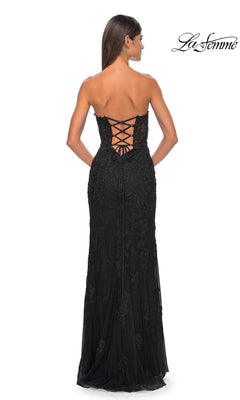 A woman in the Beaded-Lace Long Prom Dress: La Femme 32437, featuring a strapless sweetheart neckline and lace-up back, stands facing away from the camera.