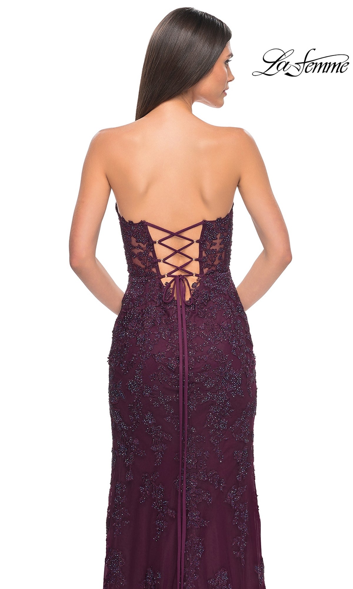 A woman is shown from behind wearing the Beaded-Lace Long Prom Dress: La Femme 32437, featuring a strapless design with a deep purple beaded lace-up back. The 