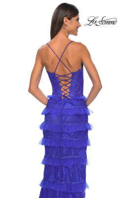 A woman faces away from the camera in the Ruffled Long Beaded-Lace Prom Dress: La Femme 32442—a blue gown with beaded lace, tulle tiers, a lace-up back, and thin crisscross straps.
