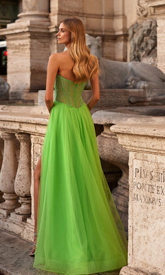A woman in the La Femme 32445 strapless long A-line prom dress with a corset-style bodice stands outdoors near a stone railing and old sculptures, facing away from the camera.