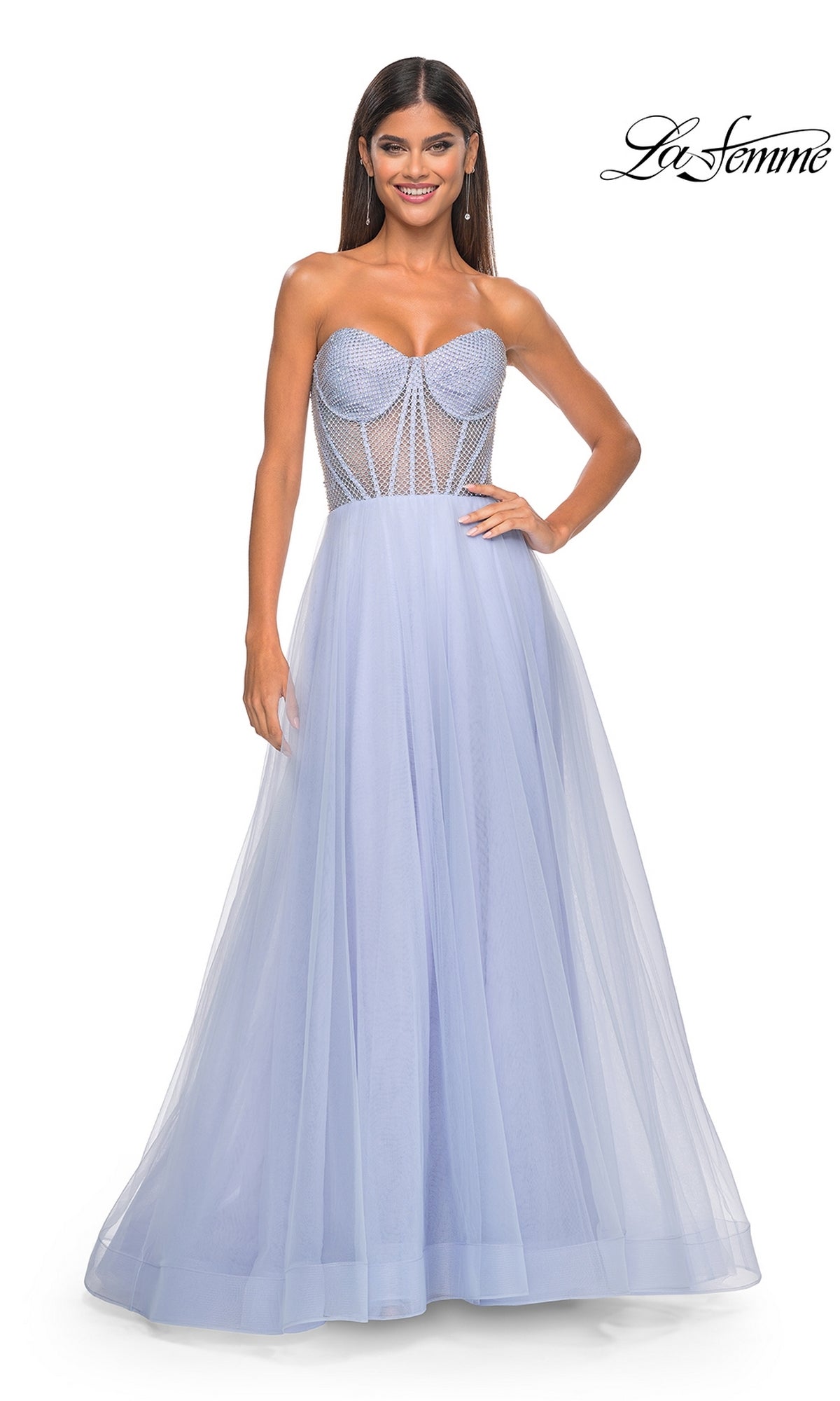 A woman in the La Femme 32445 strapless long A-line prom dress, featuring light blue tulle, a corset bodice, and structured cups, smiles against a white background.