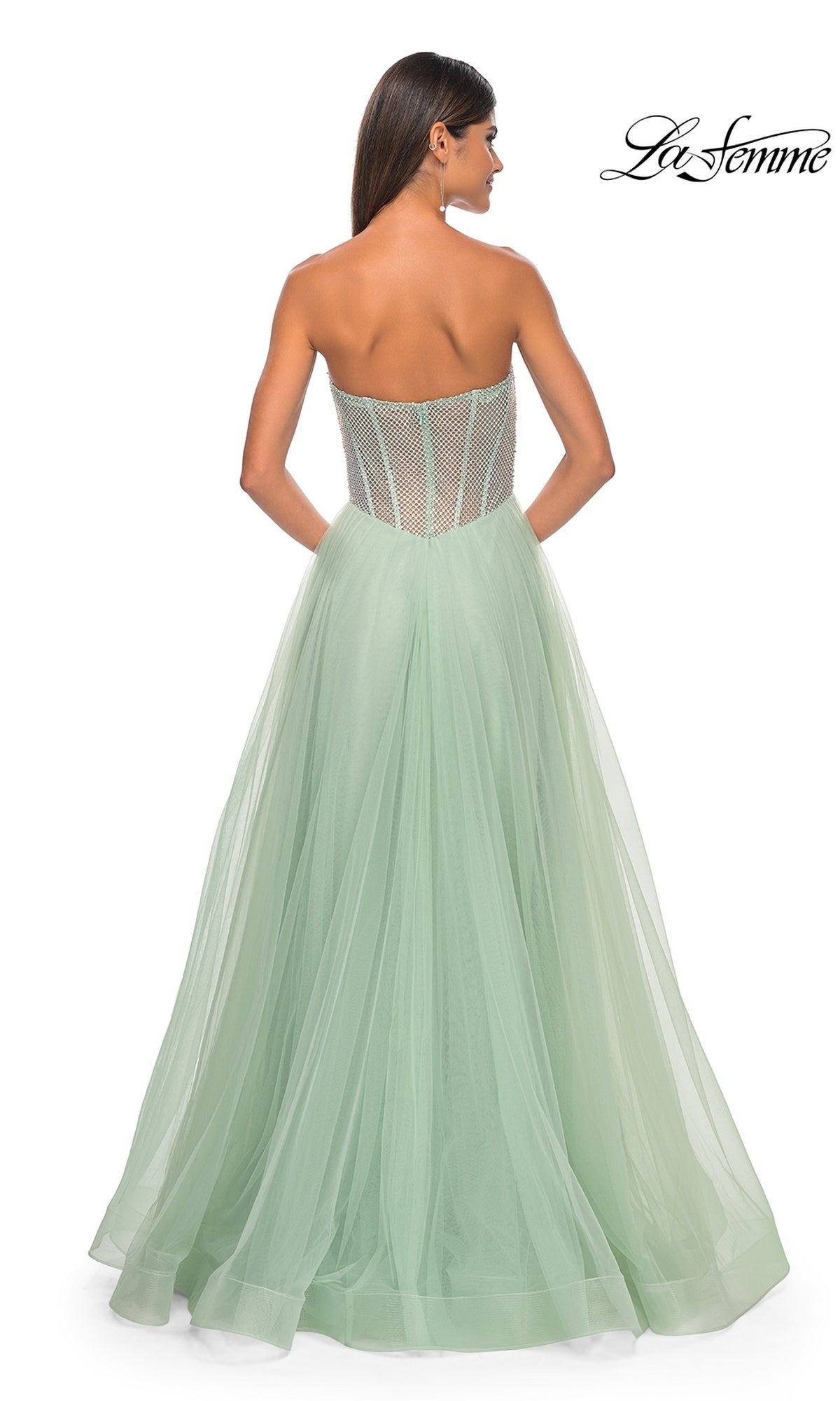 A woman is seen from the back wearing La Femme 32445, a strapless long A-line prom dress in mint green with a sheer corset-style bodice and flowing tulle skirt. La Femme logo appears in the top right corner.