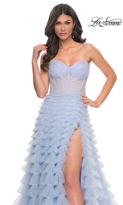 A woman models the La Femme 32447 Long Ruffled A-Line Prom Ball Gown, featuring a strapless, light blue design with a sheer bodice and high slit, against a white background. The La Femme logo is displayed in the top right corner.