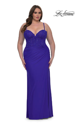 A woman wears the Plus-Size Long Corset Prom Dress La Femme 32449, a fitted royal blue gown with thin straps and beaded bodice detailing, standing against a white background.