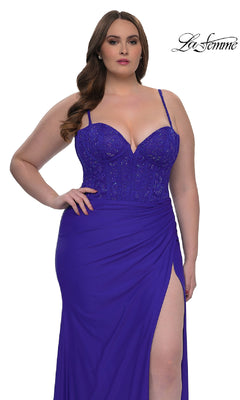 A woman wears the La Femme 32449 plus-size long corset prom dress in royal blue, featuring spaghetti straps, a lace bodice, and a thigh-high slit. The La Femme logo appears in the top right corner.