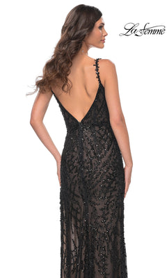 Woman in a La Femme 32450 long black beaded prom dress with a sheer overlay, thin straps, intricate details, and a stunning open back, viewed from behind.