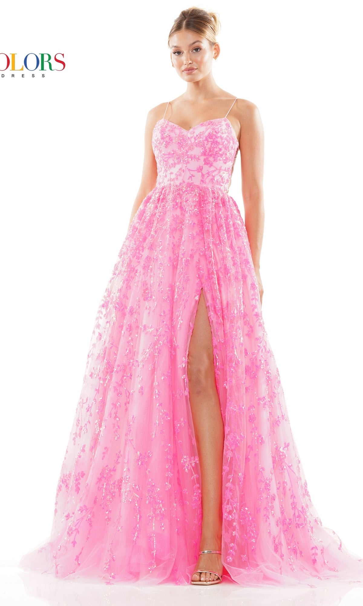 A woman wears the Sequin-Embroidered Backless Long Prom Dress 3247, featuring a bright pink hue, floral patterns, thin straps, a sweetheart neckline, and a high slit while standing against a white background.