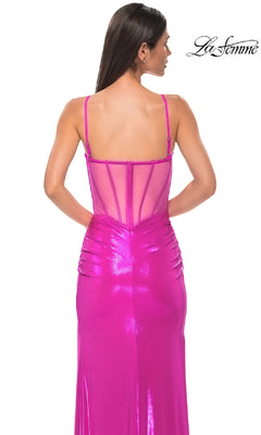 A woman is seen from behind wearing the La Femme 32526 long prom dress, a shiny bright pink metallic gown with thin straps, a sheer-back bodice, and gathered side details.