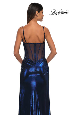 Woman wearing the Long Prom Dress: La Femme 32526—a metallic blue gown with a sheer-back bodice and thin straps—stands with her back to the camera. "La Femme" appears in the top right corner.