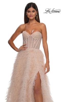 A woman stands against a plain white background wearing the La Femme 32528 Strapless Ruffled Prom Ball Gown, a long dress with a corset-style bodice, sheer accents, feathered skirt, and thigh-high slit. "La Femme" logo appears in the corner.