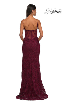 A woman stands with her back to the camera in a sleeveless, floor-length La Femme 32529 Sheer-Sides Long Beaded Prom Dress featuring thin straps and a sheer back panel.