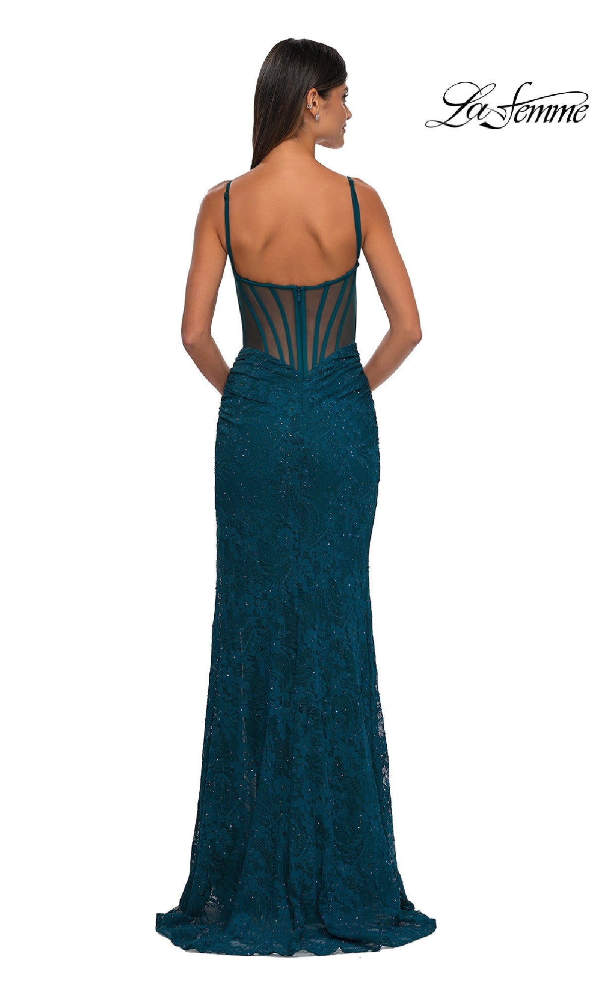 A woman wearing the Sheer-Sides Long Beaded Prom Dress La Femme 32529, featuring teal beaded lace, thin straps, and a sheer back panel, stands with her back to the camera. The La Femme logo appears in the top right corner.