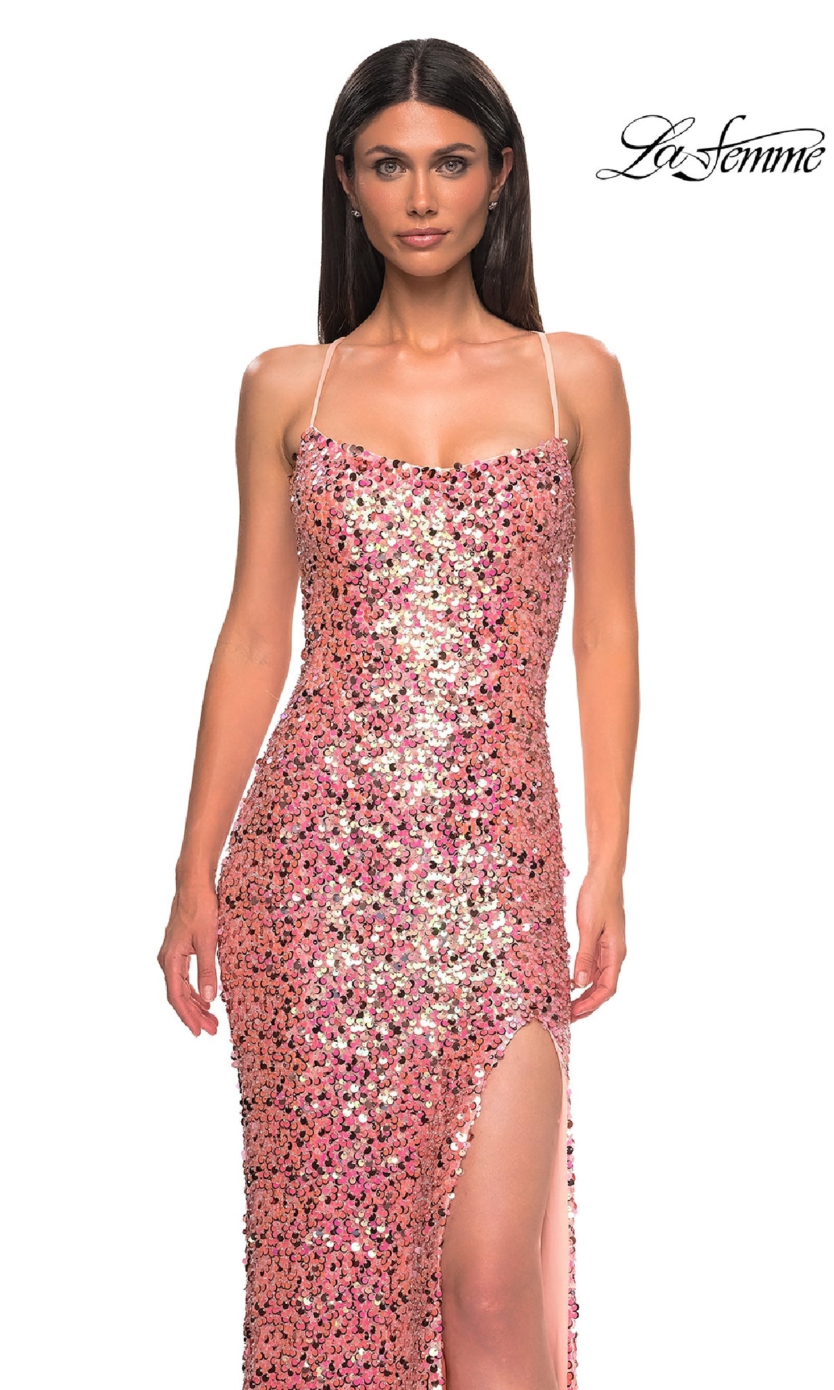 A woman models the Long Pink Prom Dress: La Femme 32550, featuring thin straps, a high leg slit, and a strappy open back, with pink sequins. She stands against a white background with the 