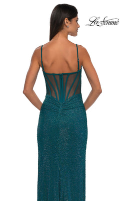 Woman shown from behind in a teal, sparkly, fitted La Femme 32578 long beaded prom dress with thin straps and a sheer back panel featuring structured lines. The La Femme logo appears in the top right corner.
