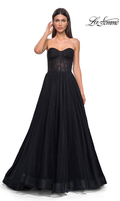 Woman wearing the Strapless Long Prom Ball Gown: La Femme 32579, featuring a fitted floral corset-style bodice and full black skirt, standing against a plain white background.