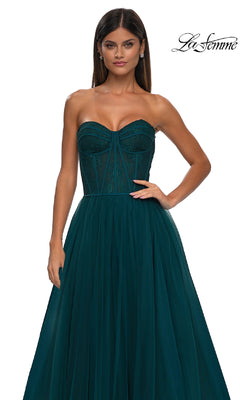 A woman wears the Strapless Long Prom Ball Gown: La Femme 32579, featuring a sweetheart neckline, fitted floral corset bodice, and flowing tulle skirt, standing against a white background with the "La Femme" logo in the top right corner.