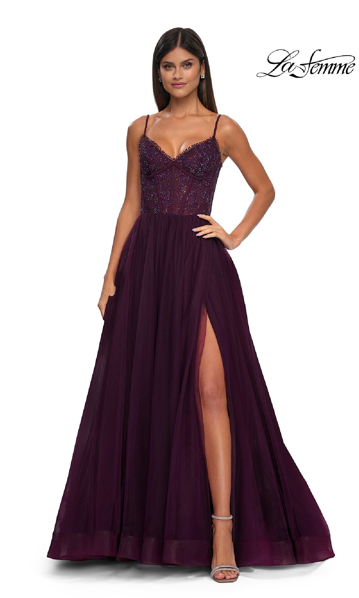 A woman wears the Beaded-Bodice Long Prom Ball Gown: La Femme 32594—floor-length, deep purple, with spaghetti straps, a beaded bodice, and a high side slit—standing against a plain white background.