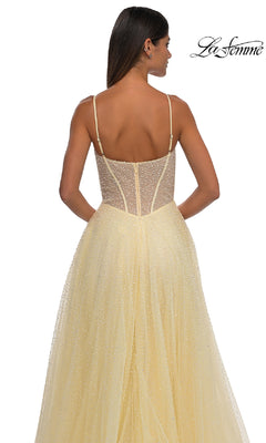 Woman facing away in the Pearl Classic Long Prom Dress: La Femme 32644—a yellow, floor-length A-line gown with thin straps and a sheer, pearl-beaded bodice; "La Femme" logo in top right corner.