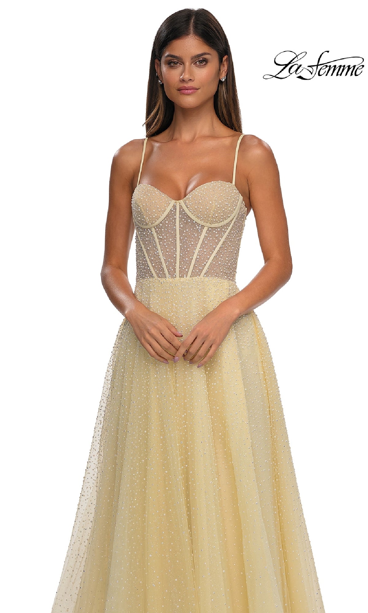 A woman wears the Pearl Classic Long Prom Dress: La Femme 32644—a yellow gown with pearl beading, a sheer corset bodice, and thin straps—standing against a white background. The La Femme 32644 logo is in the top right corner.