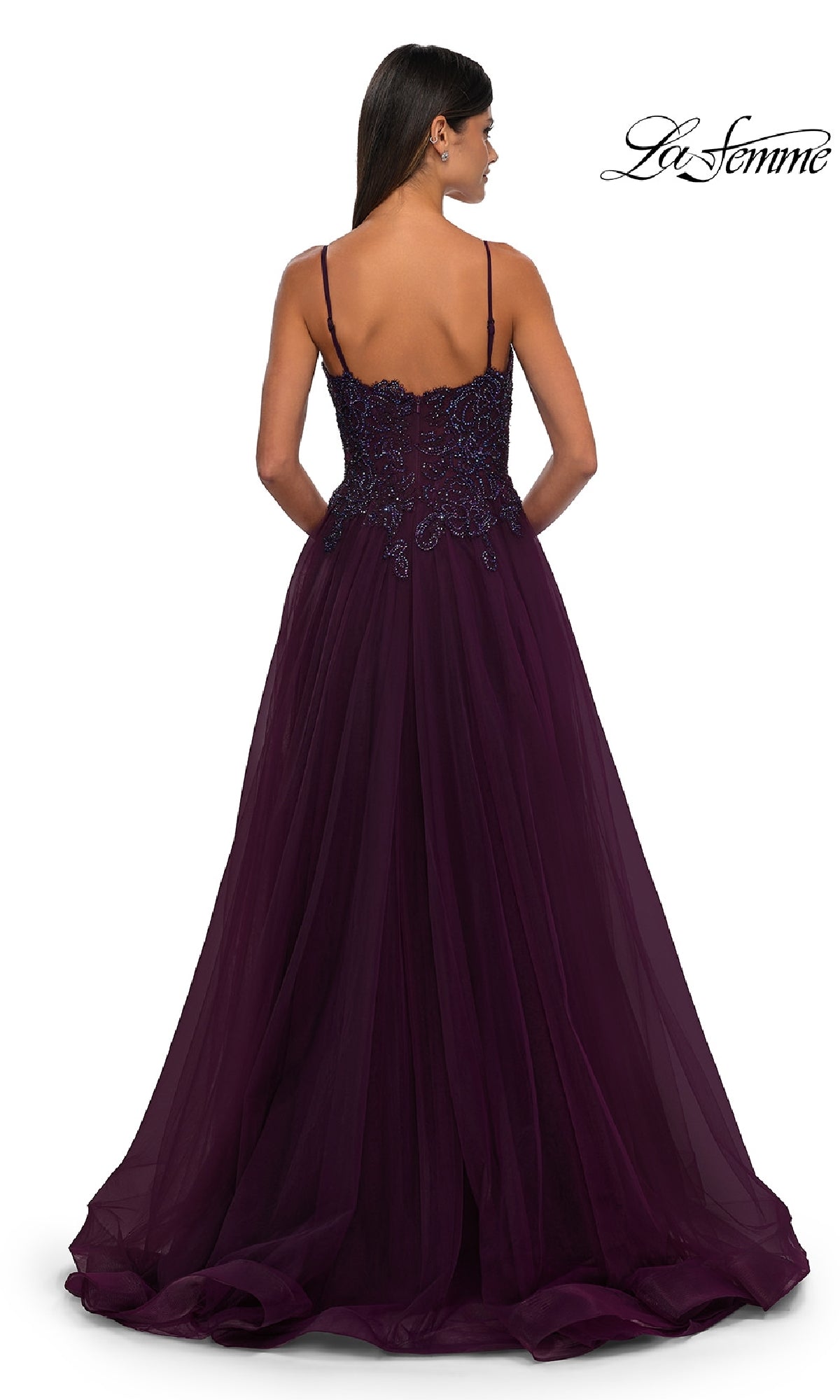A woman is shown from the back in the La Femme 32646, a long prom ball gown with pockets. The deep purple dress features spaghetti straps, a beaded bodice, and a flowing tulle A-line skirt for a stunning silhouette.