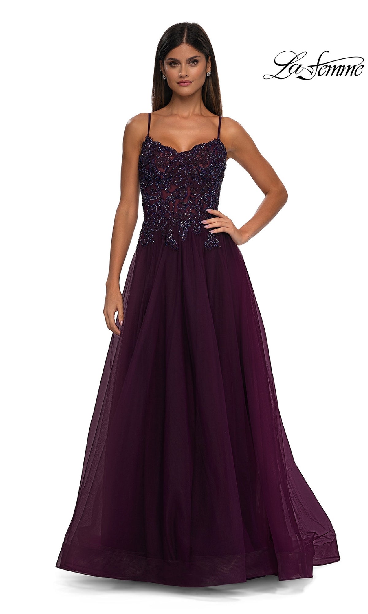 A woman stands against a plain white background wearing the La Femme 32646, a sleeveless, floor-length dark purple prom ball gown with pockets, featuring a beaded lace bodice and a flowing tulle skirt.