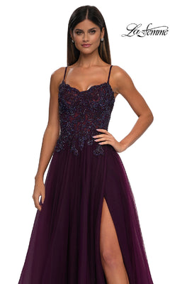 Woman in a sleeveless deep purple La Femme 32646 long prom ball gown with pockets, beaded bodice, and thigh-high slit, standing against a white background. "La Femme" logo is in the upper right corner.