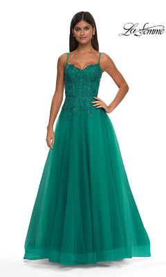 A woman stands against a white background wearing the La Femme 32646 long prom ball gown with pockets, featuring a sleeveless emerald green design, beaded bodice, and tulle skirt.